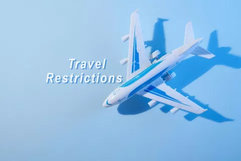 Travel restrictions text with a mini airplane