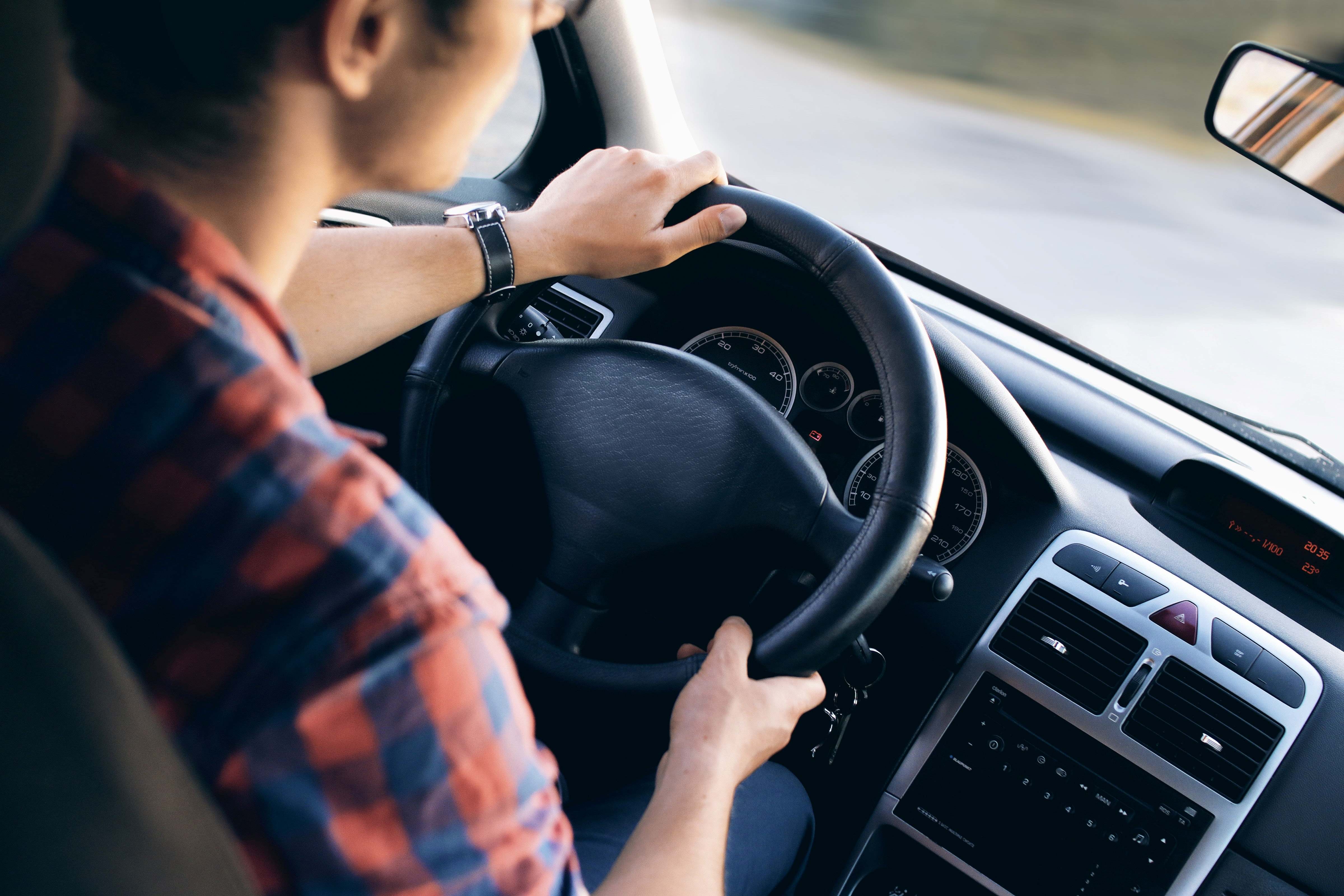 Stock image of person behind the wheel of a car.