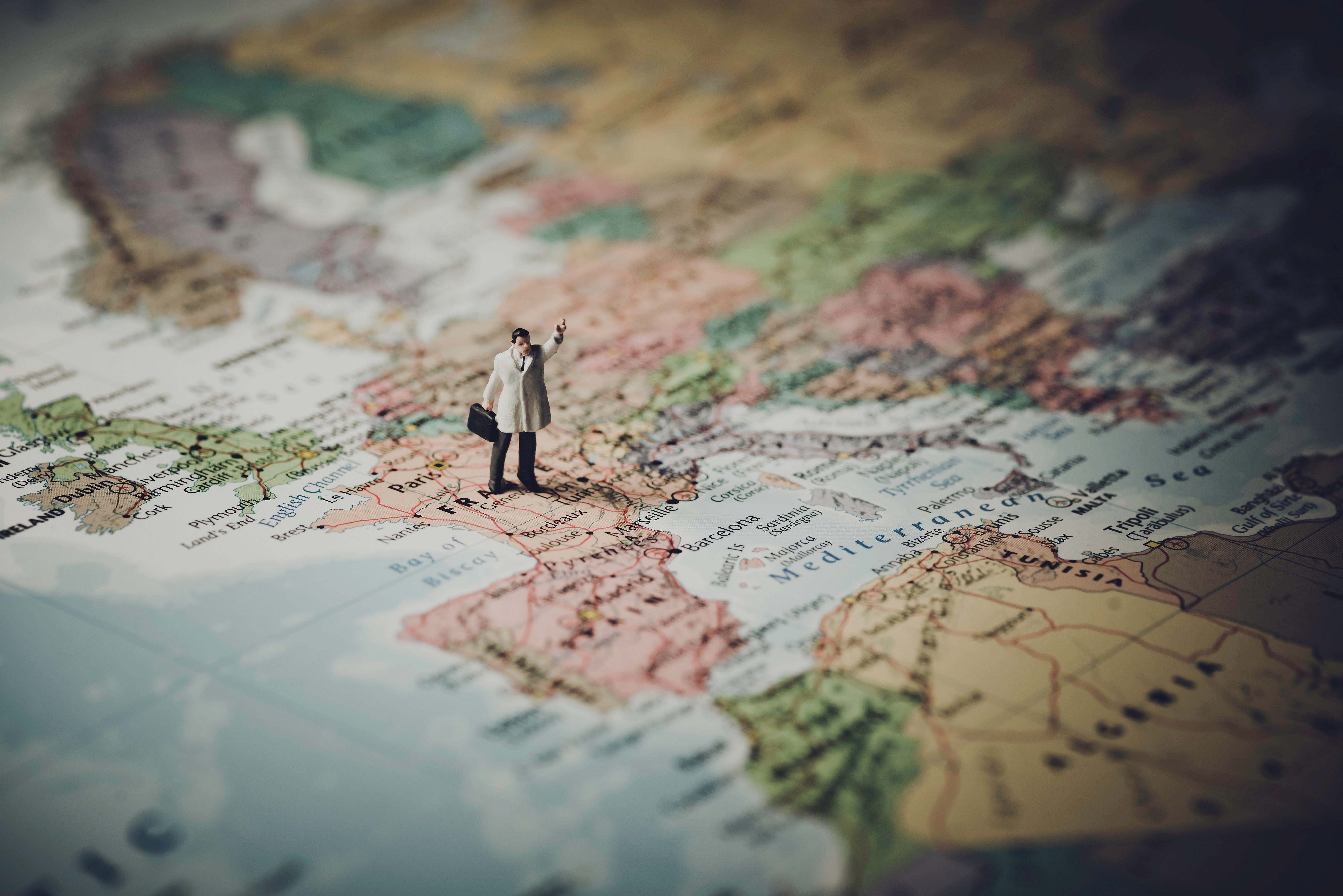 Figurine of a man standing on a map.